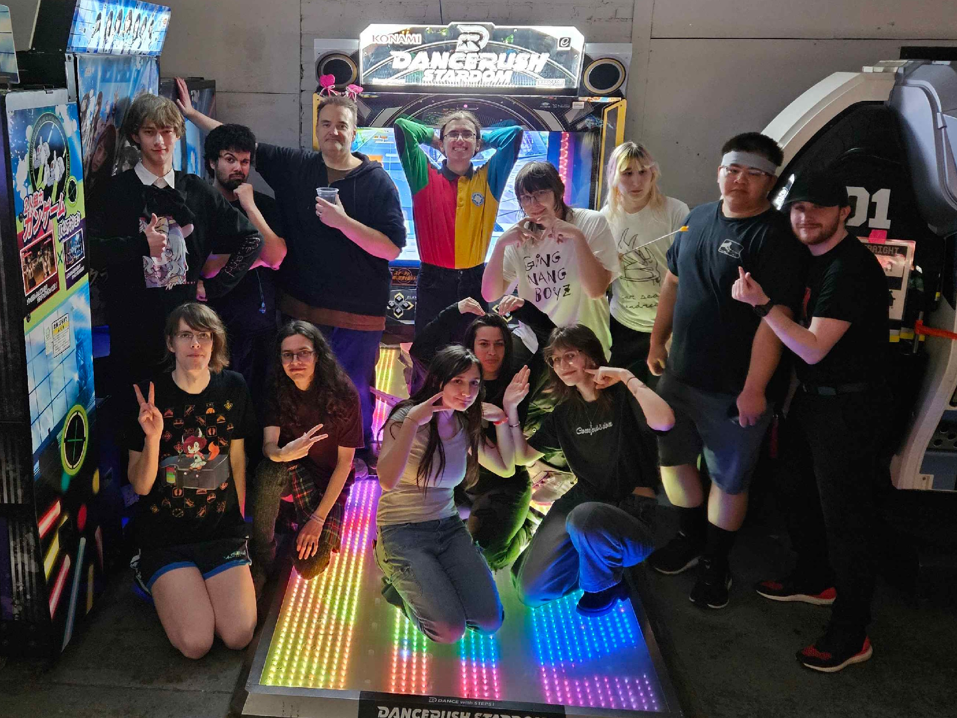 People standing in front of a Dancerush Stardom cabinet